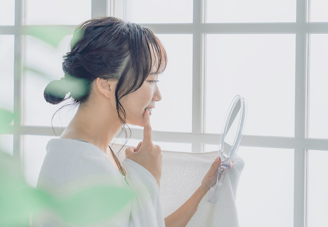 矯正治療中の歯を気にする女性のイメージ